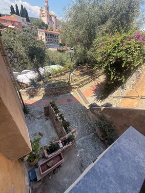 A courtyard with stone walls, a fountain, and a view of a historic building in the background. - Terrazza Palazzo Viale Cervo (Cervo)