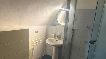 Un baño con ducha, lavamanos e inodoro.