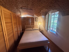 A room with a bed, a window, and a wooden ceiling. - TERRAZZA PALAZZO VIALE CERVO (Cervo)