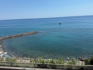 A coastal view with a rocky breakwater, clear blue water, and a few boats. - Terrazza Palazzo Viale Cervo (Cervo)