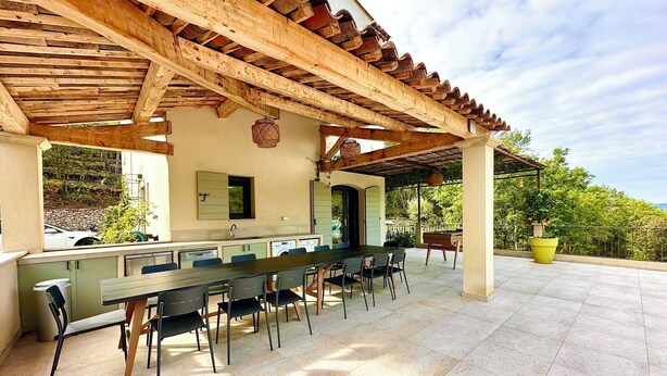 An outdoor patio with a long dining table, chairs, and a pergola overhead. - Villa de La Verdière, perfect for families (La Verdière)
