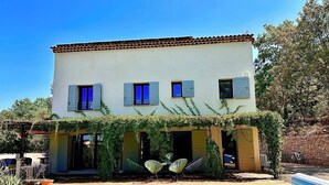 A two-story building with a swimming pool, outdoor seating, and a covered patio area. - Villa de La Verdière, perfect for families (La Verdière)
