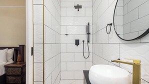 Un baño moderno con ducha, lavamanos y espejo.