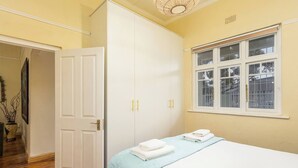Un dormitorio con cama, armario, ventana y puerta.