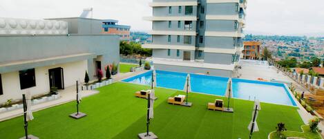 A rooftop pool area with a view of a cityscape.