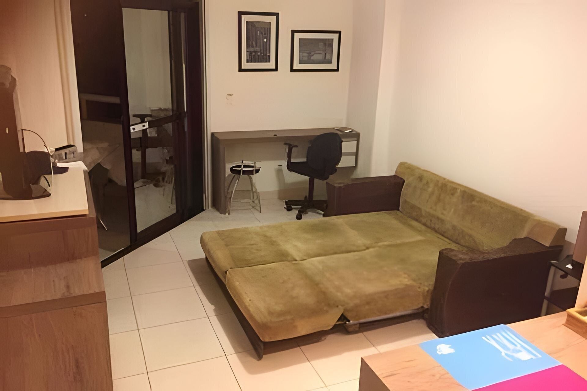 A compact living space with a sofa, a desk, and a chair.
