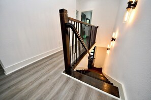 Eine Treppe mit Holzdielen und einem schwarzen Metallgeländer.