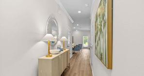 A hallway with a wooden console table, two lamps, a mirror, and a painting on the wall. - Bayside Getaway - Near Beach (Orange Beach)