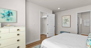 A bedroom with a bed, a dresser, a door leading to a bathroom, and a shower. - Bayside Getaway - Near Beach (Orange Beach)