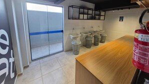 Des toilettes modernes avec des cloisons en verre, plusieurs lavabos et un comptoir en bois.