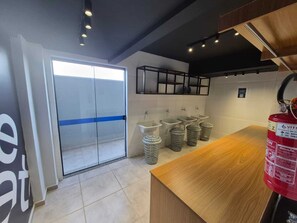 Des toilettes modernes avec des cloisons en verre, plusieurs lavabos et un comptoir en bois.