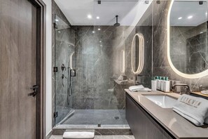 A modern bathroom with a glass shower enclosure, a vanity with a mirror, and a towel rack. - The Signature Eleven and Pool (Miami)