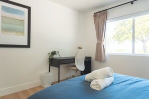 A bedroom with a bed, a desk, a chair, a window with curtains, and a framed picture on the wall. - Luxury Escape, Backyard Pool & Hillside Views (Los Angeles)