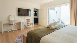 A hotel room with a bed, a desk with a chair, a television, and a bathroom visible through an open door. - Luxury Escape, Backyard Pool & Hillside Views (Los Angeles)