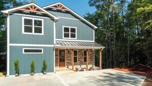 A two-story house with a porch, a garage, and a driveway. - Escape to a peaceful retreat with breathtaking golf course views in Helen.  (Helen)