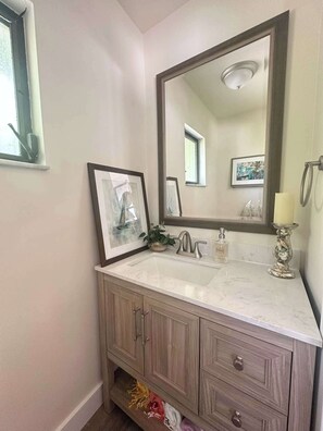 A bathroom with a large mirror, a sink, a vanity with drawers, and a window. - Villa Van Vista Luxury Gulf Access Retreat (Cape Coral)