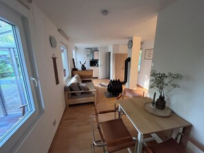 A compact living space with a kitchenette, a dining area, and a seating area with a sofa and chairs. - A Heartwarming Vacation: Swedish-style house | Sauna | Canoe | SUP | Private dock included | 1 min. to the lake (Lychen)
