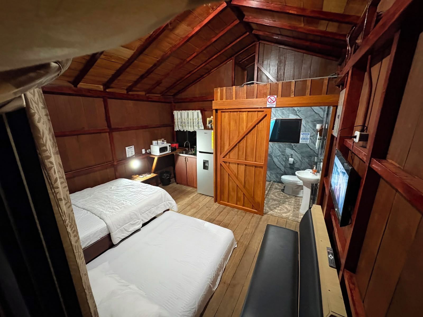 Ein kleines Zimmer mit zwei Betten, einer Küchenzeile und einem Badezimmer.
