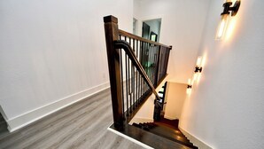 Eine Treppe mit Holzdielen und einem schwarzen Metallgeländer.