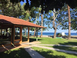 A covered outdoor seating area with a view of the sea.