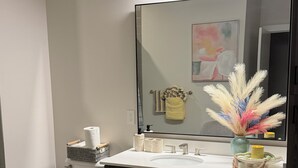 Un baño moderno con inodoro, lavabo, tocador y espejo.