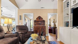 A living room with a brown leather sofa, a coffee table with a bowl of popcorn, and a wooden cabinet. - Vineyard Estate & Water Tower | Hot Tub | Views (Sebastopol)