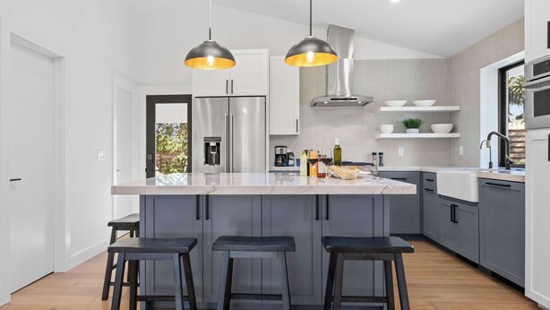 A modern kitchen with a central island, bar stools, pendant lighting, and built-in appliances. - Sonoma Retreat w/ Deck, Views & BBQ (Sonoma)