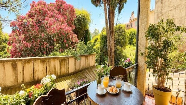 An outdoor patio with a round table, chairs, and a potted plant. - The House of Observance (DRAGUIGNAN)