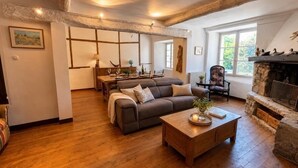 A cozy living room with a fireplace, wooden flooring, and a sofa. - The House of Observance (DRAGUIGNAN)