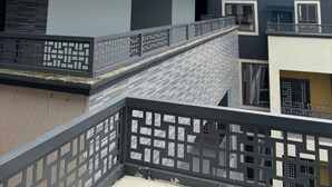 Ein modernes Gebäude mit Glasfassade, einer Treppe und einem Balkon mit Geländer.
