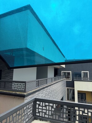 Ein modernes Gebäude mit Glasfassade, einer Treppe und einem Balkon mit Geländer.