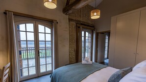 Une chambre avec un grand lit, une armoire et une vue par la fenêtre.