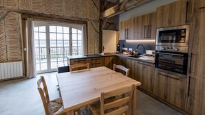 Une cuisine moderne avec des meubles en bois, un îlot central et des appareils électroménagers intégrés.