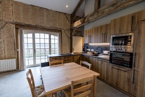 A modern kitchen with wooden cabinetry, a central island, and built-in appliances. - CHAURRON 2 - ARTHEZ D'ARMAGNAC (ARTHEZ D'ARMAGNAC)