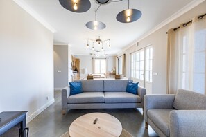 A modern living room with a grey sofa, a round coffee table, and pendant lighting. - PASQUET 2 - ARTHEZ D'ARMAGNAC (ARTHEZ D'ARMAGNAC)