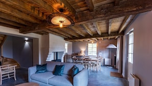Una sala de estar acogedora con sofá, una mesa y un comedor con sillas.