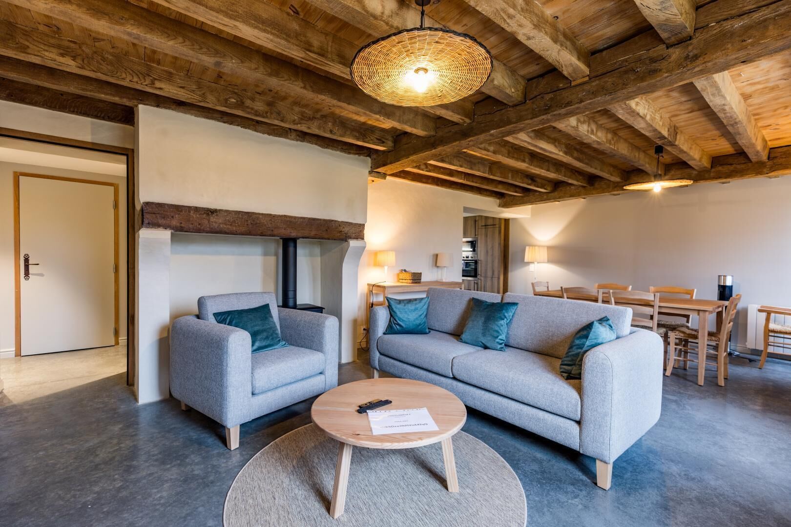 Ein gemütliches Wohnzimmer mit Kamin, zwei Sofas, einem Couchtisch und einem Essbereich.