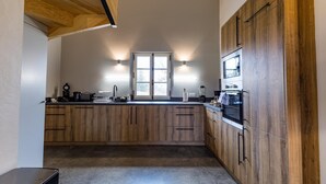 Une cuisine avec des meubles en bois, une fenêtre et des appareils électroménagers intégrés.