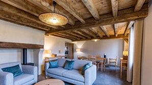 Un salon confortable avec un canapé, une table basse et un coin repas comprenant une table et des chaises.