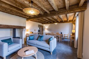 A cozy living room with a sofa, a coffee table, and a dining area with a table and chairs. - POUYLABRIN 2 - ARTHEZ D'ARMAGNAC (ARTHEZ D'ARMAGNAC)