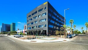 A modern building with a flat roof, multiple windows, and a sign indicating the address 1030. - The Neon Circuit Loft (Phoenix)