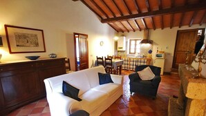 A cozy living room with a sofa, armchairs, a dining area, and a kitchen. - Villa Opera - Apartment in Florence (Toscana)