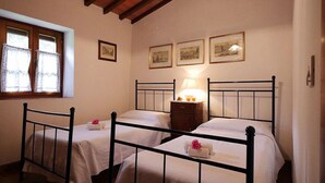 A room with two single beds, a nightstand with a lamp, and a window with curtains. - Villa Opera - Apartment in Florence (Toscana)