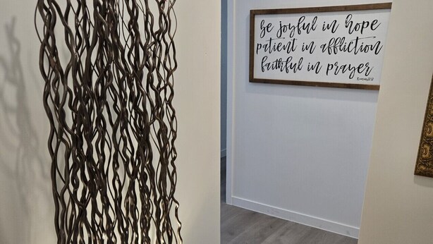 A hallway with a decorative metal wall art piece and a framed inspirational quote on the wall. - Phoenix Rustic Urban Retreat (Phoenix)