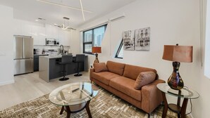 Un appartement moderne comprenant un espace de vie, une cuisine et un coin repas.