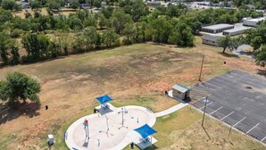 An aerial view of a park with a circular walking path, benches, and shaded areas. - Bison Hill Bungalow | 3 blks from OBU (Shawnee)