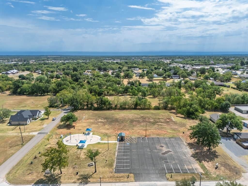 Vista aèria d'una zona residencial amb cases, un aparcament i un petit parc infantil.
