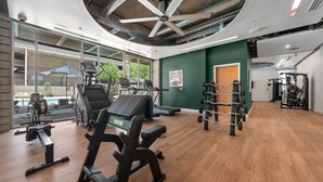 Une salle de sport équipée de machines de cardio, d’appareils de musculation et dotée d’un mur entièrement recouvert de miroirs.