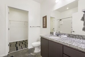 A bathroom with a shower, toilet, and vanity with a mirror. - Phoenix Downtown Zen Loft (Phoenix)