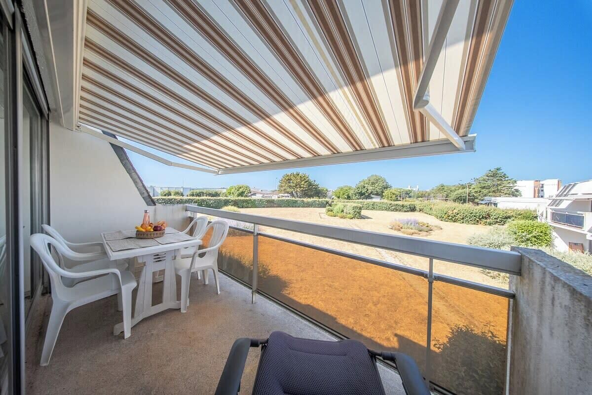 Un balcon avec une table, des chaises et un canapé.